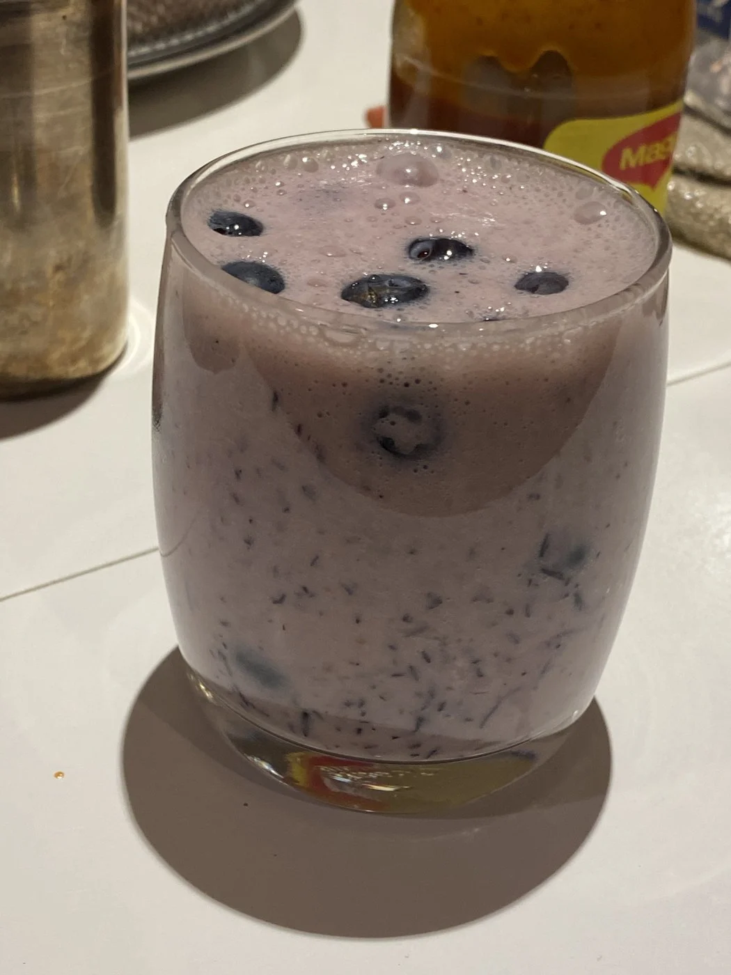 A close view of a blueberry-topped purple drink on the counter.