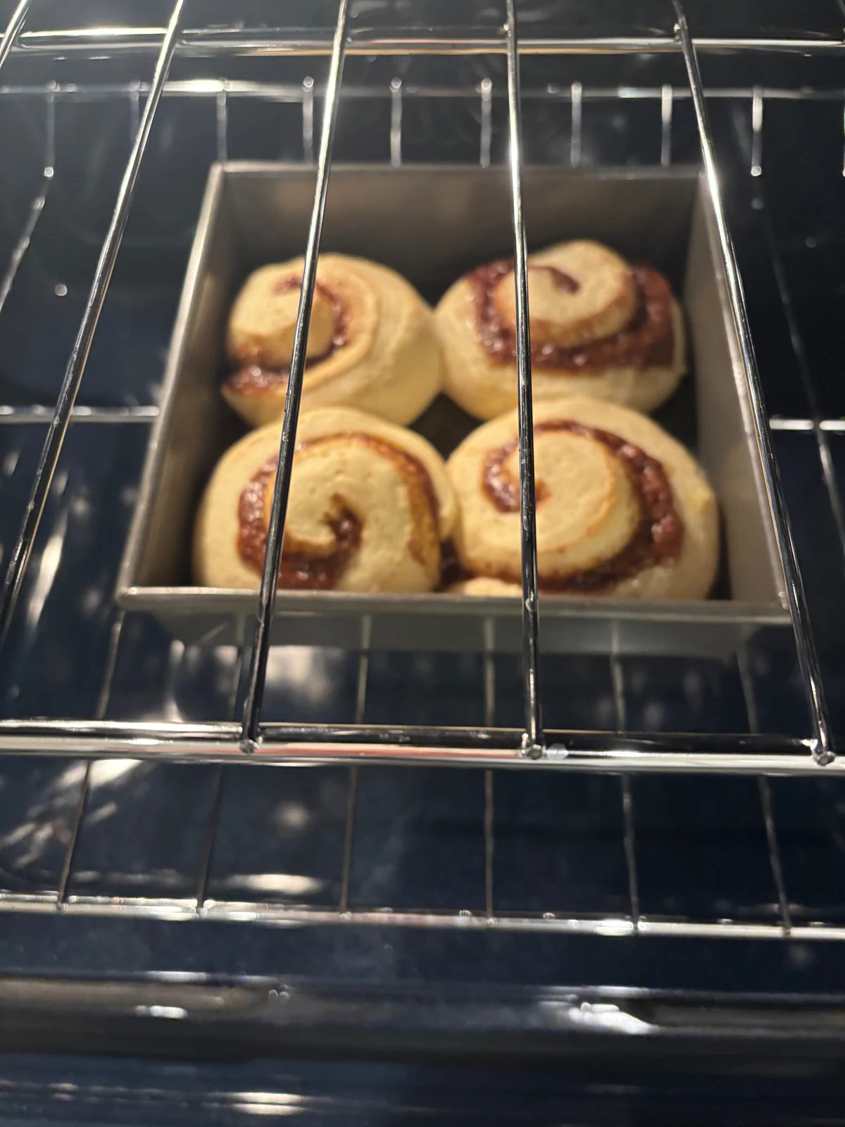 Four spiral rolls baking in a loaf tin.