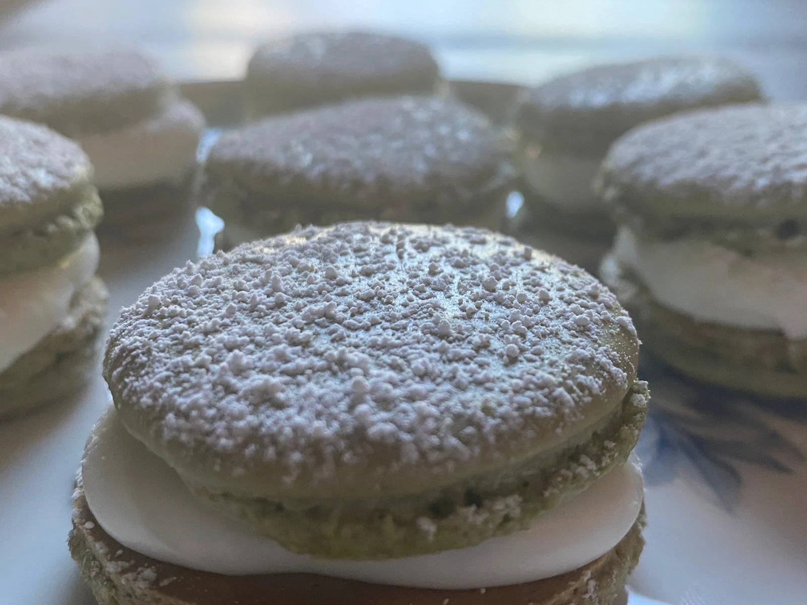 Smooth round green shells with ruffled feet, thick white filling and powdered sugar.