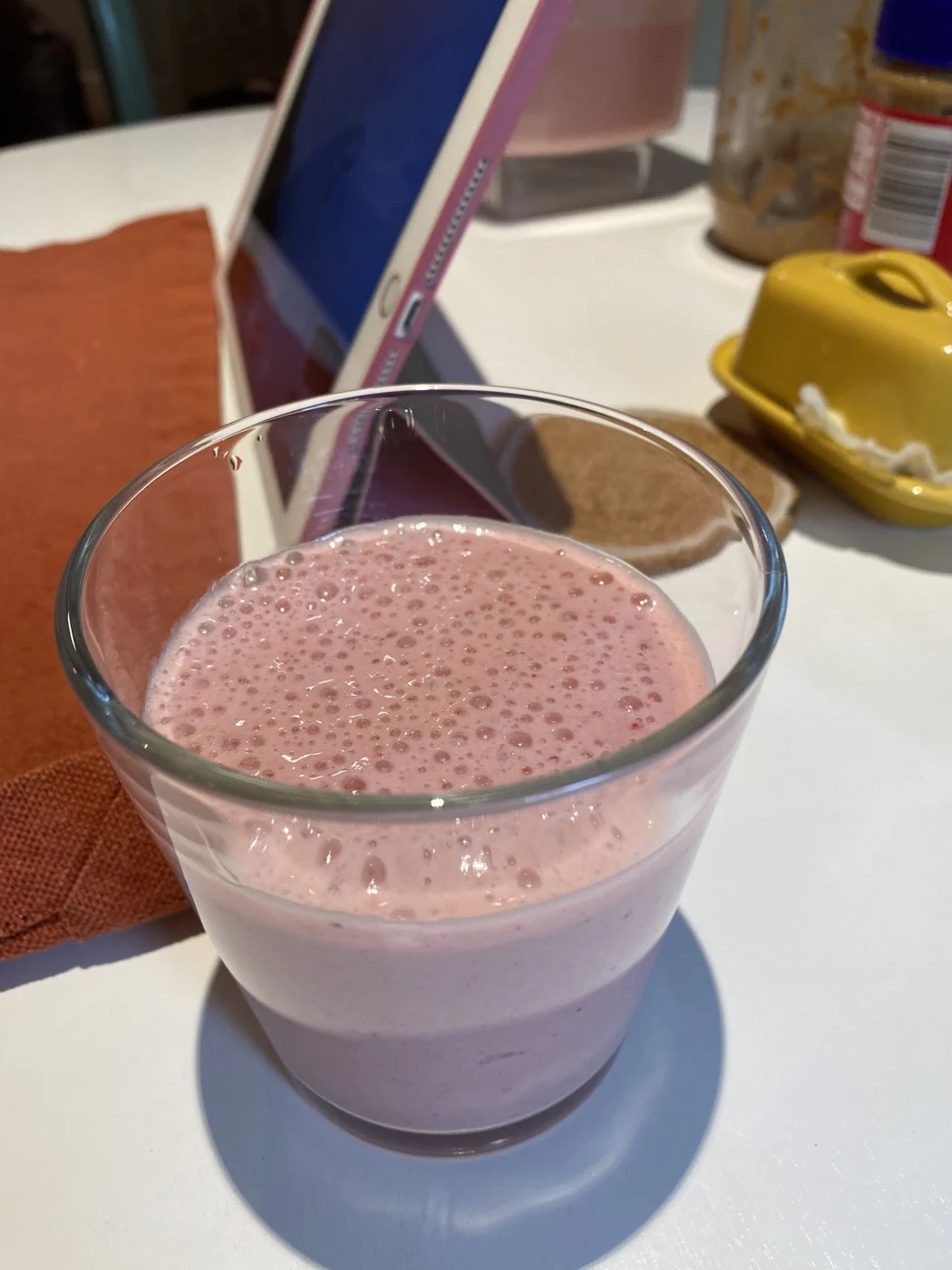 One freshly blended pink drink with a foamy surface.